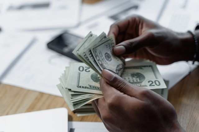 person handling cash at a desk